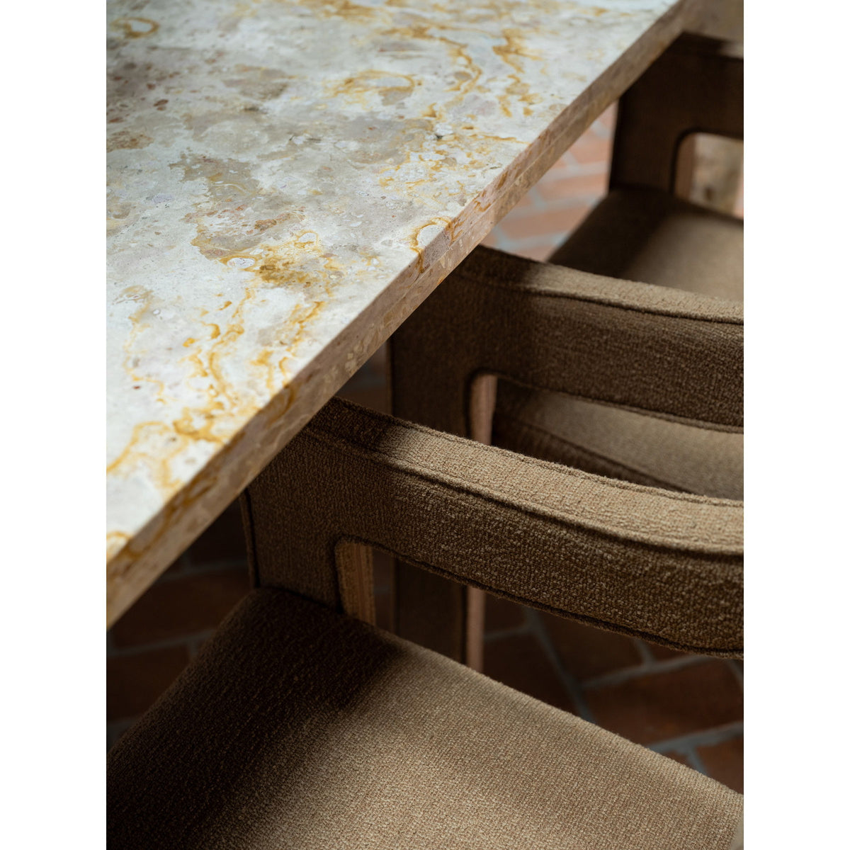 Stone tabletop edge above dining chair seats, showing pedestal base detail