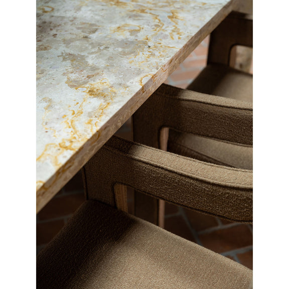 Stone tabletop edge above dining chair seats, showing pedestal base detail