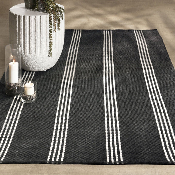 Charcoal rug with wide vertical ivory stripes and textured flat weave
