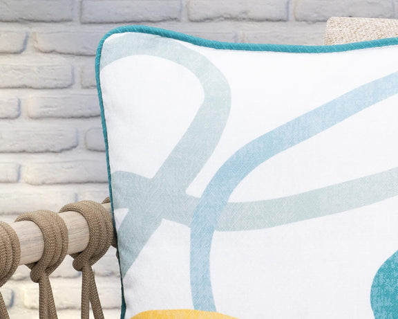 Square cushion close-up with teal-bordered abstract blue and yellow shapes.