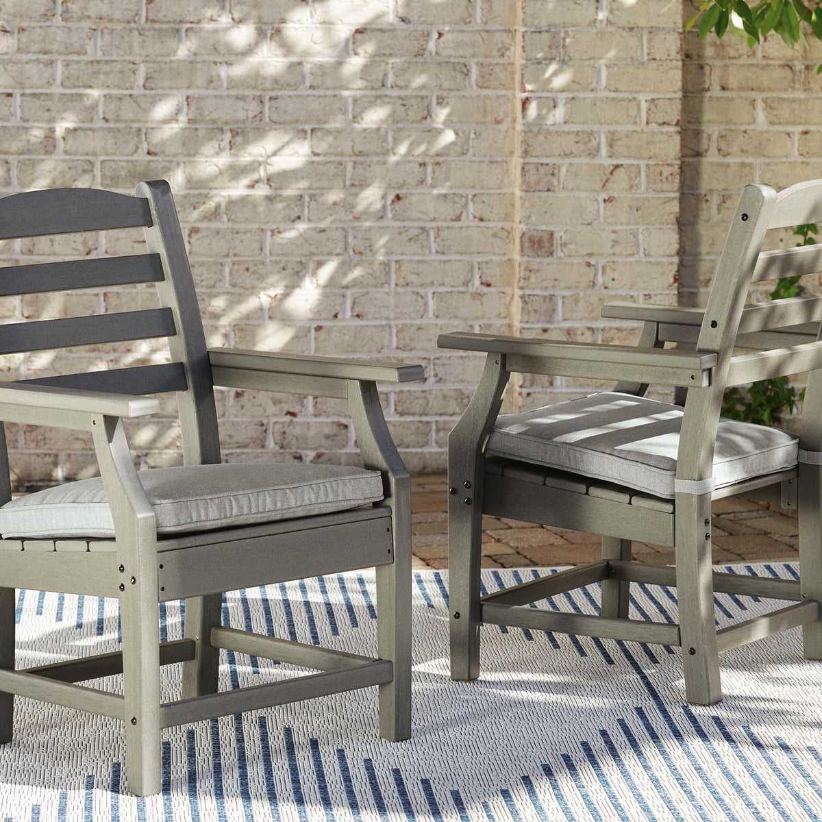 Set of 2 gray arm chairs with light gray cushions and slatted backs, wooden frames