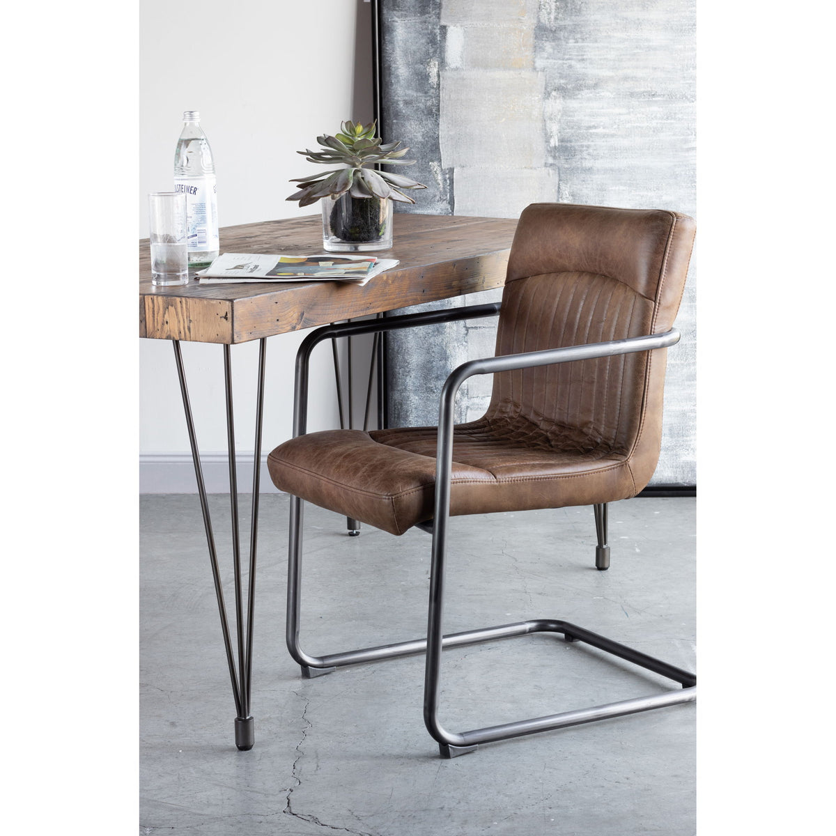 Brown leather arm chair with metal frame, cushioned seat and arms