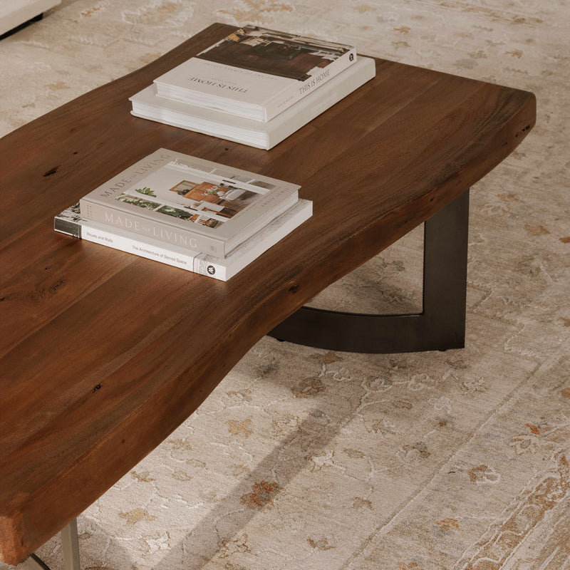 Smoked wood coffee table with dark metal legs and magazine display on top