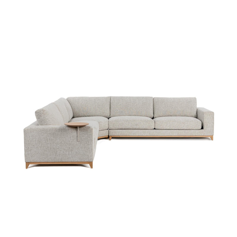Light sand sectional sofa with chaise-style corner, tufted seat cushions, and wood legs.