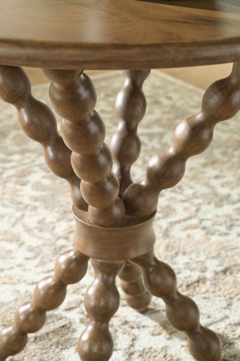 Close-up of light brown accent table turned trestle legs