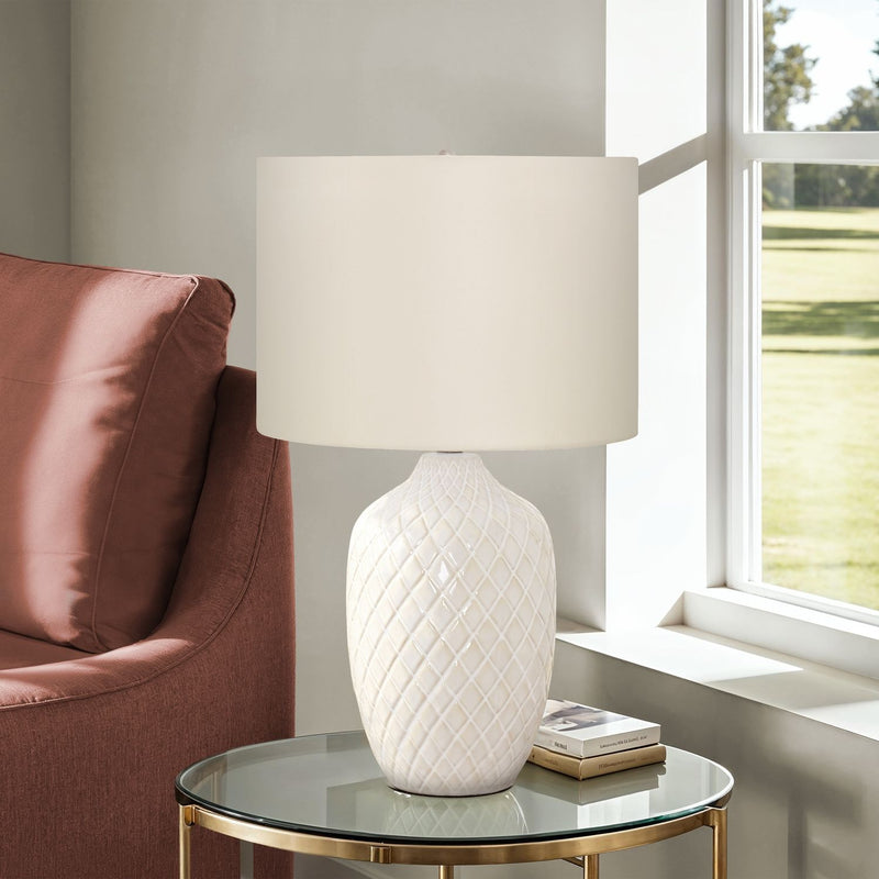 Cream table lamp with white drum shade and diamond-textured ceramic base on round top