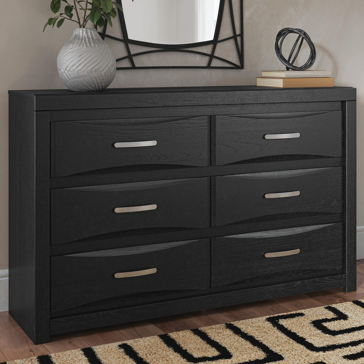 Black six-drawer dresser with mirror; six bar pull handles on drawer fronts.