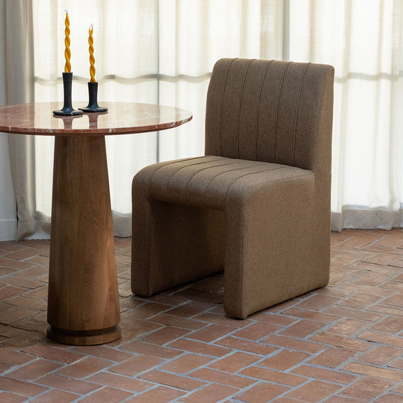 Light brown upholstered dining chair with tall backrest, channel stitching, and thick seat
