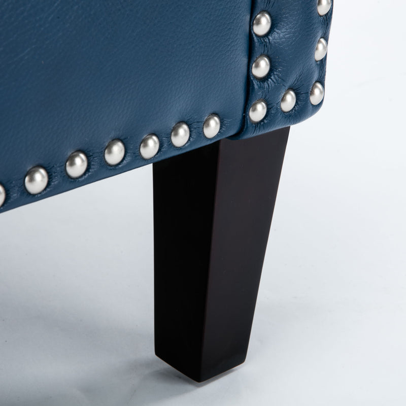 Blue club chair leg and nailhead trim close-up, dark tapered legs