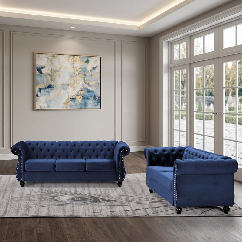 Blue three-seat button-tufted sofa with rolled arms, tufted cushions and studs