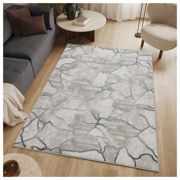 Gray area rug with abstract map-like pattern and blue accents, centered in living room