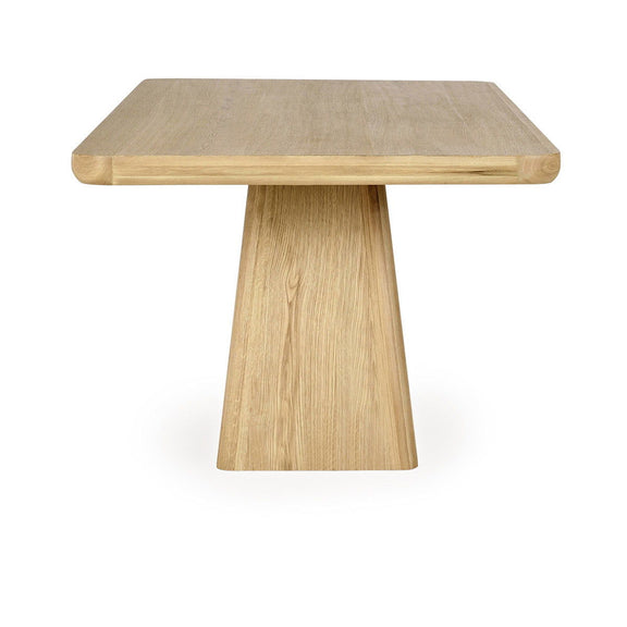Light wood dining table with square pedestal base and wide tabletop