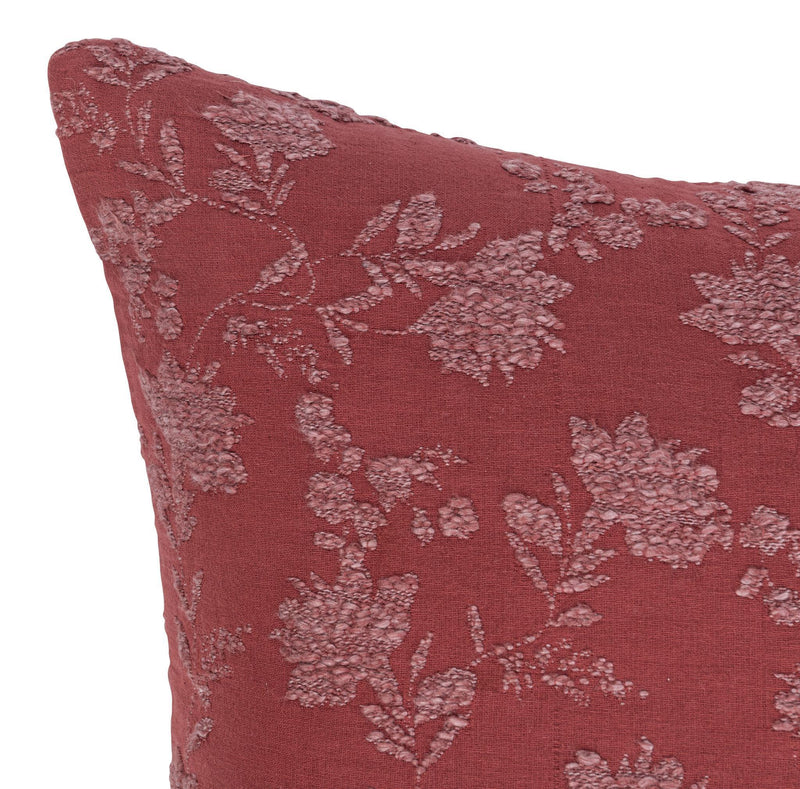 Burgundy red pillow face with light floral vine pattern, close-up texture and stitching.