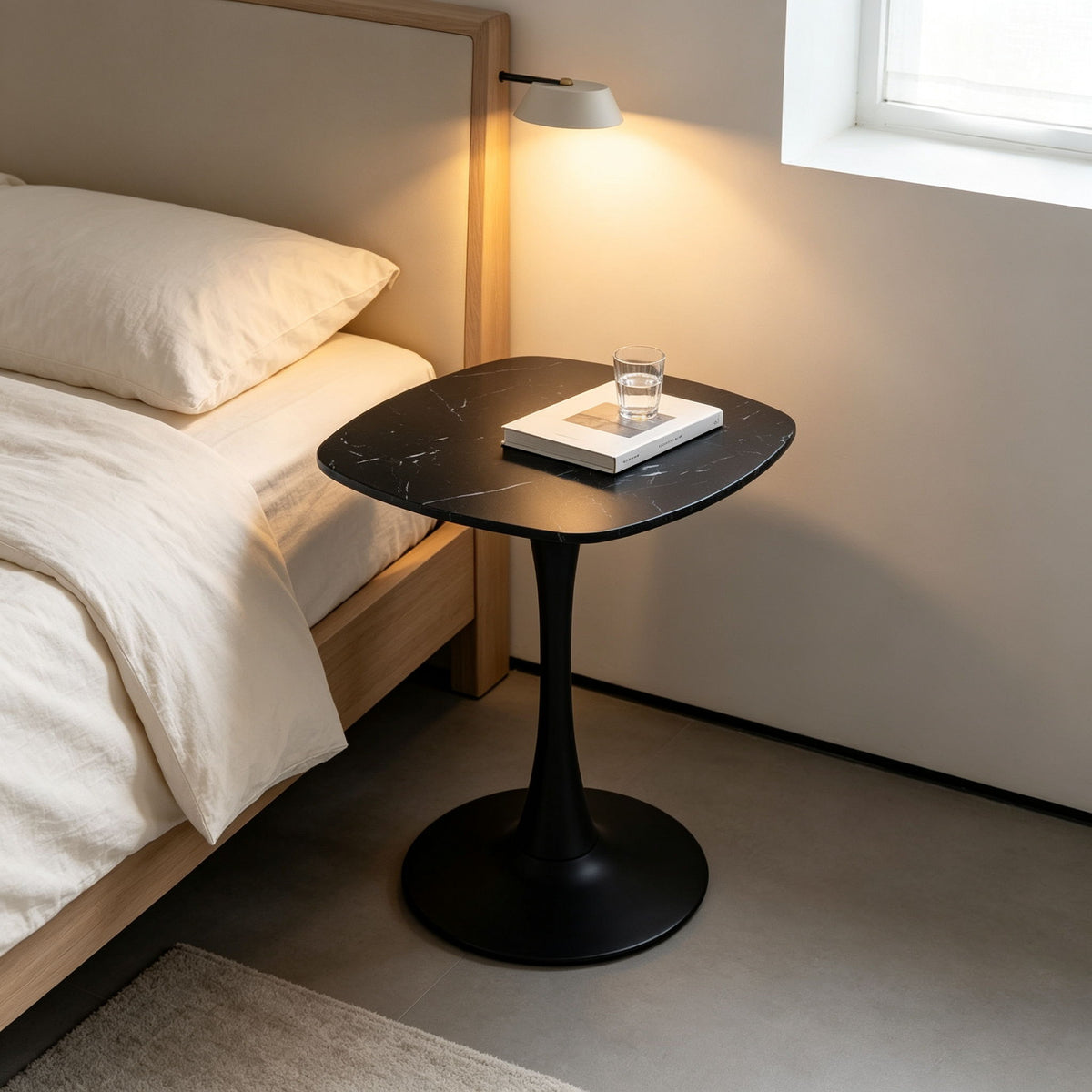 Black rounded-square table with single pedestal base for dining or side use
