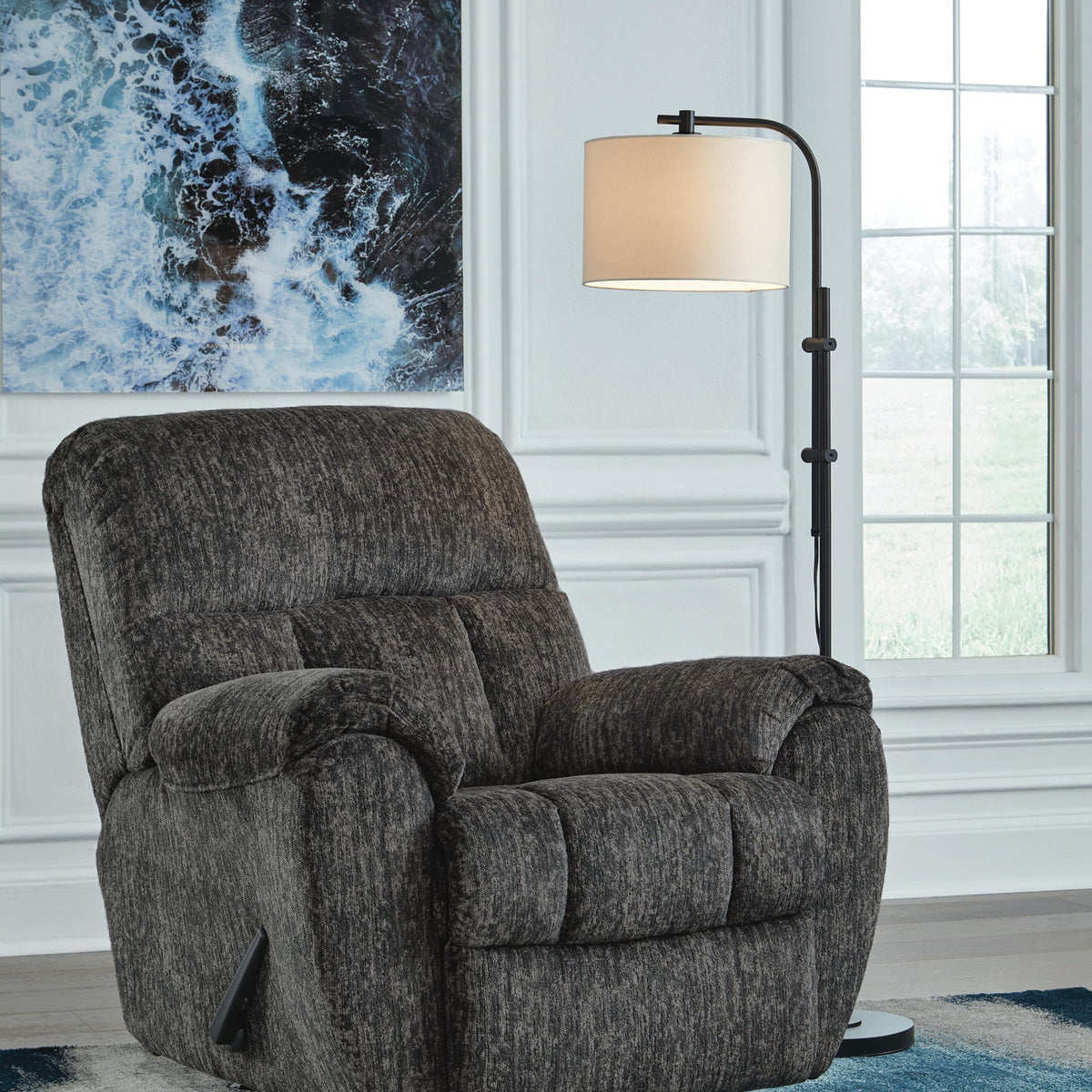 Dark gray rocker recliner chair with padded arms and cushioned backrest