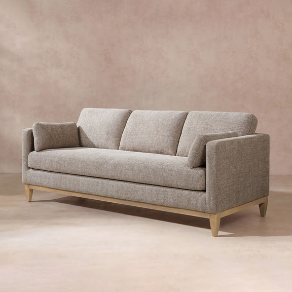 Light beige textured fabric sofa with squared seat back, rounded arms, and wood legs