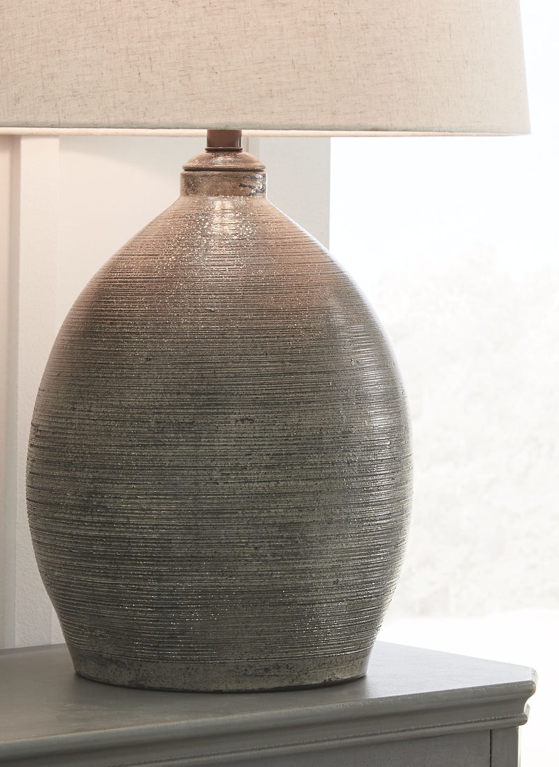 Gray textured ceramic table lamp with beige drum shade and close-up base