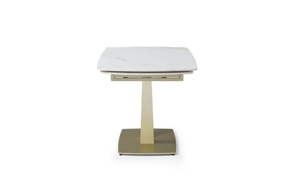Dining table with white marble-look top and gold pedestal base, front angled view