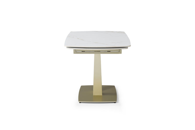 Dining table with white marble-look top and gold pedestal base, front angled view