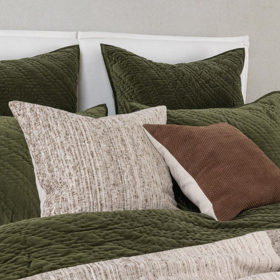 Quilted velvet bedding set in dark green with matching pillows and textured accents