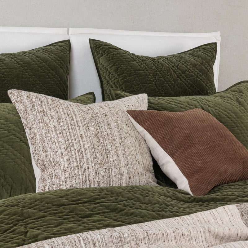 Quilted velvet bedding set in dark green with matching pillows and textured accents