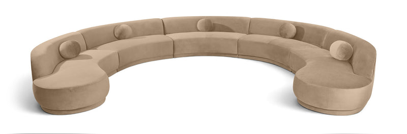 Light beige velvet sectional sofa with rounded, button-tufted seat cushions.