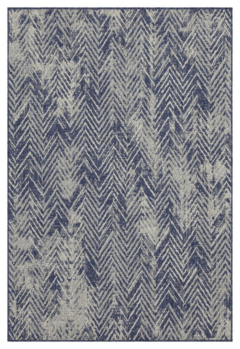 Blue indoor/outdoor area rug close-up with white zigzag chevron pattern, flat weave.