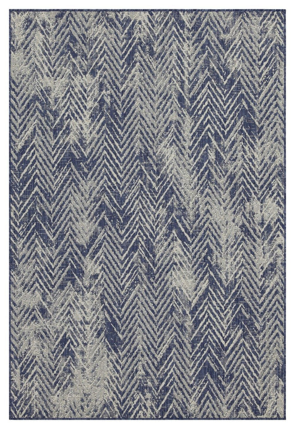 Blue indoor/outdoor area rug close-up with white zigzag chevron pattern, flat weave.