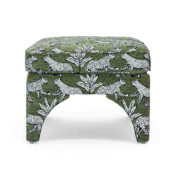 Upholstered ottoman in dark green with white jungle animal print, round padded top, arched legs