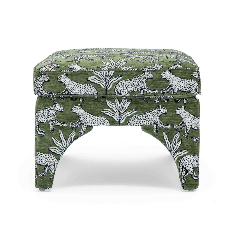 Upholstered ottoman in dark green with white jungle animal print, round padded top, arched legs