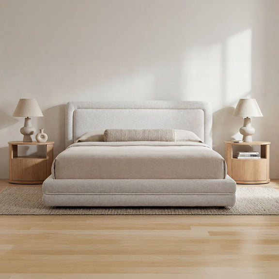 Queen upholstered bed with light pebble gray headboard and matching fabric base, with bedding.