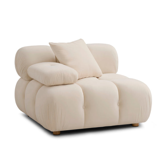 White corner chair with padded arms, tufted cushions, and two throw pillows