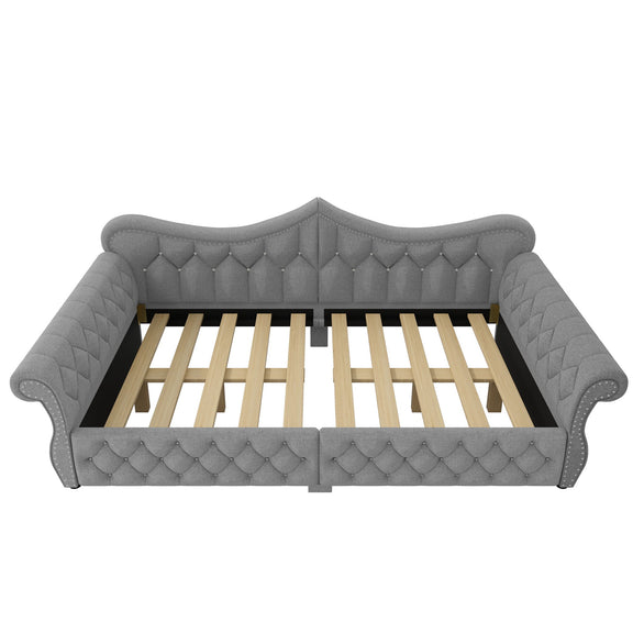 Light gray upholstered daybed with tufted panels and slatted base