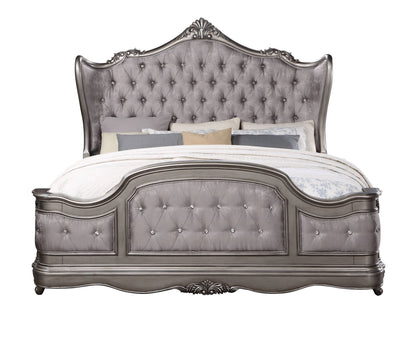Silver tufted upholstered bed with ornate carved headboard and footboard
