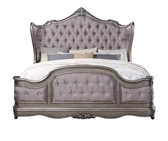 Silver tufted upholstered bed with ornate carved headboard and footboard