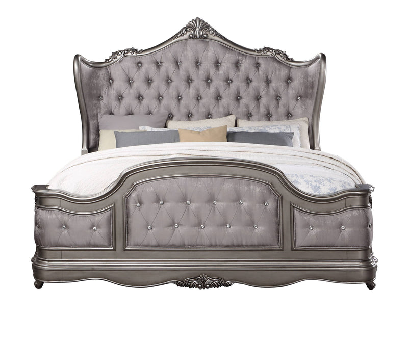 Silver tufted upholstered bed with ornate carved headboard and footboard