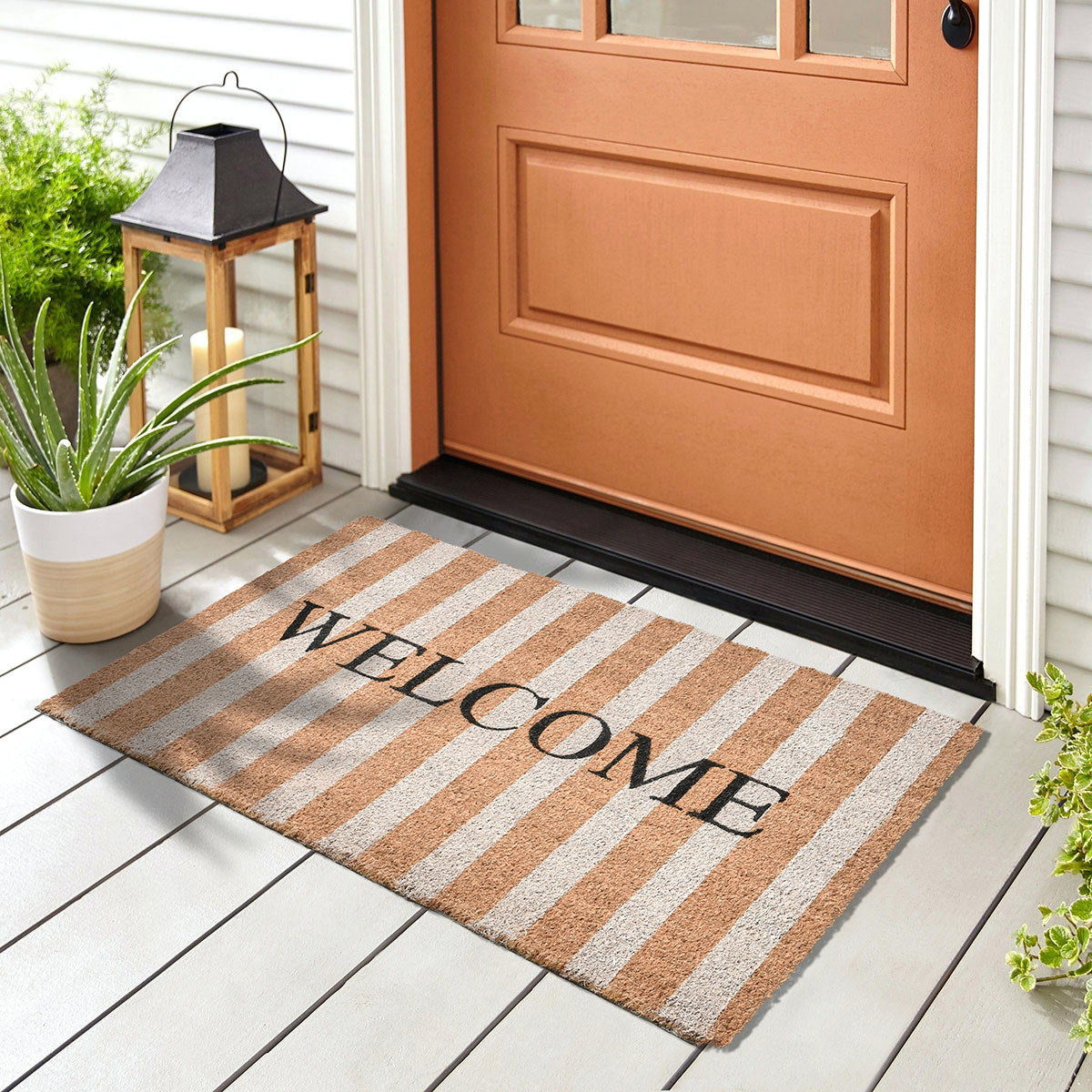 Striped welcome doormat with tan, white stripes and black 'WELCOME' text