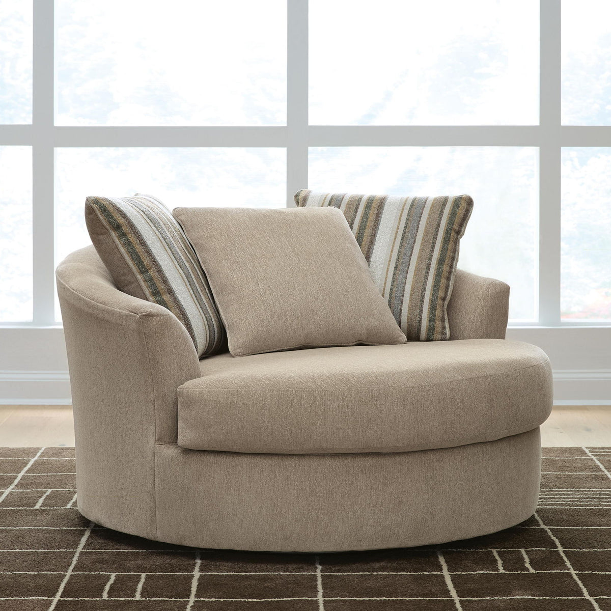 Oversized swivel accent chair in light beige with two striped back cushions and solid cushion