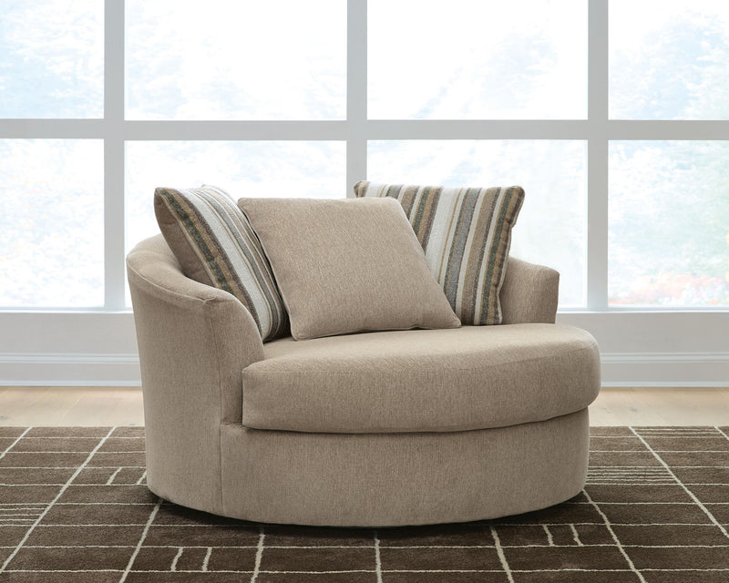 Oversized swivel accent chair in light beige with two striped back cushions and solid cushion