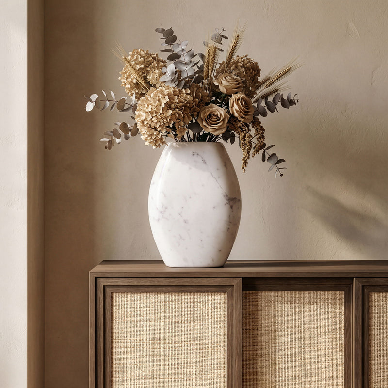White marble vase holding dried floral arrangement