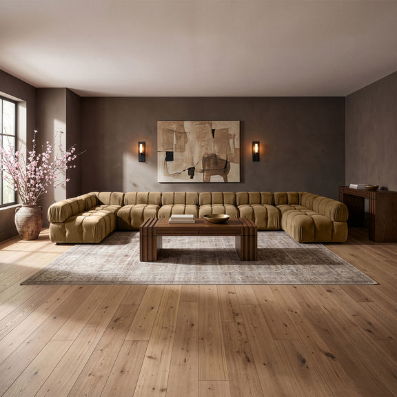 Beige modular sectional sofa with tufted cushions and curved chaise corner design