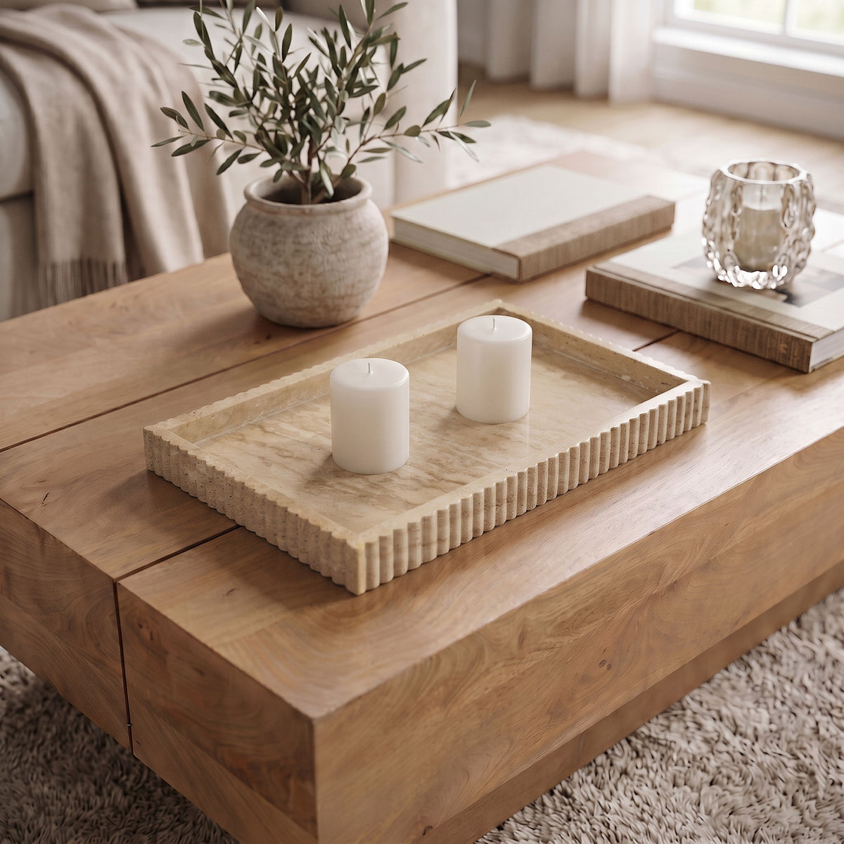 Beige travertine tray with ridged sides, holding two white candles