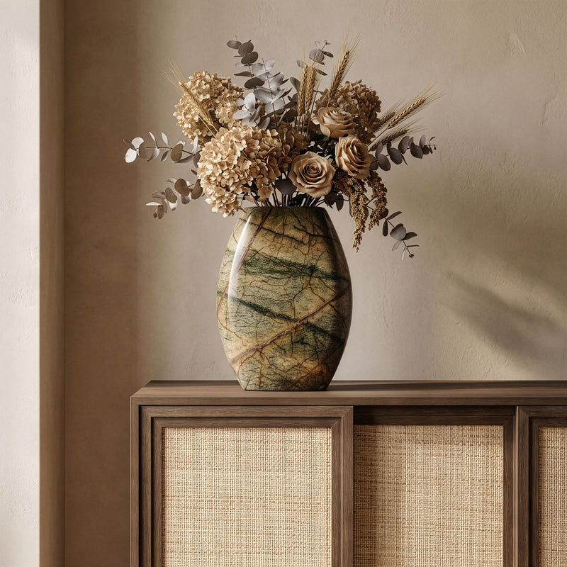 White marble vase with dried floral arrangement and green veining