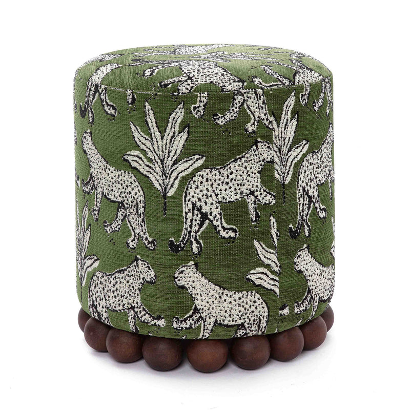 Dark green animal-print ottoman with dark wood ball base; round, cushioned top.