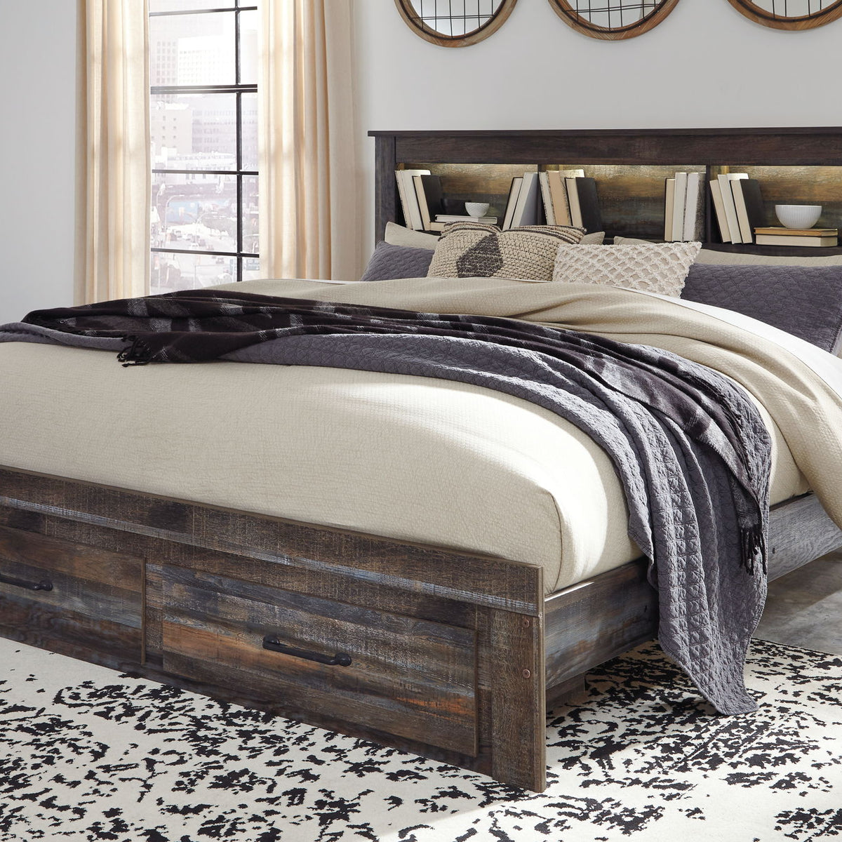 Panel bookcase bed in dark wood with two front drawers and beige-gray layered bedding