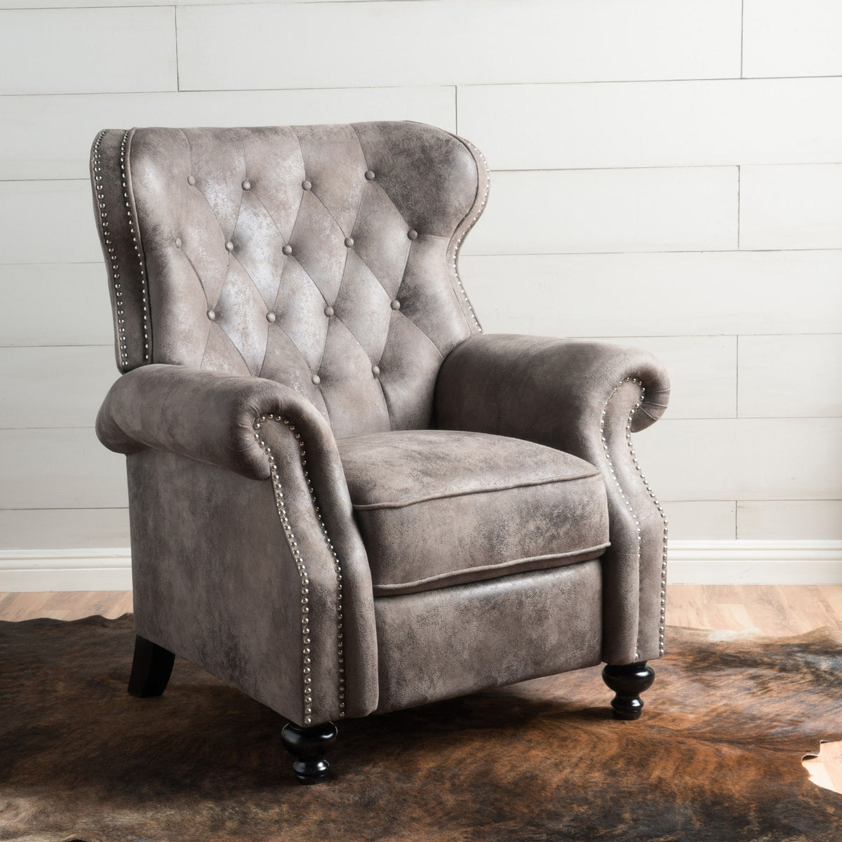 Dark gray push-back recliner chair with button-tufted back and nailhead accents