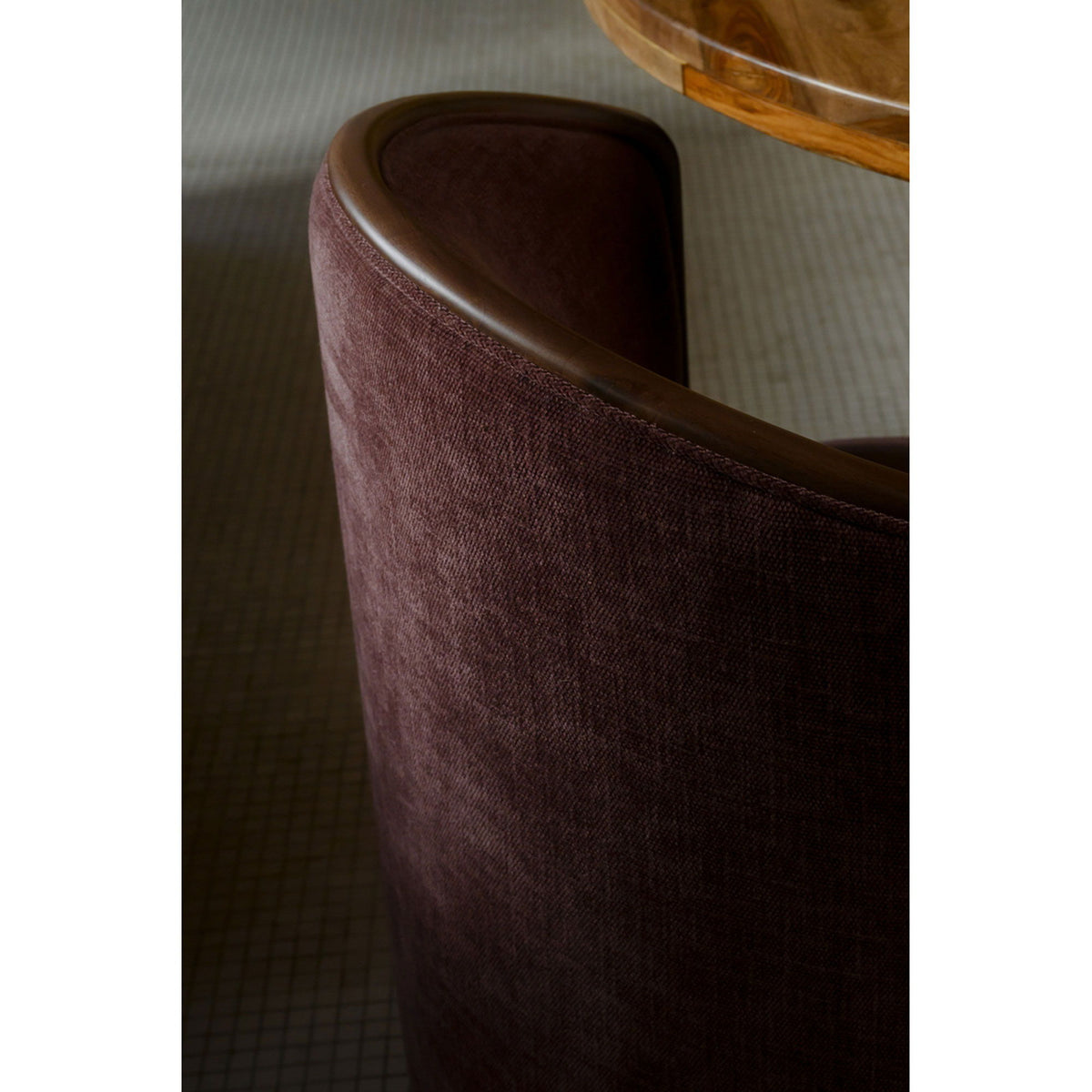Berry upholstered chair back side detail with curved brown trim