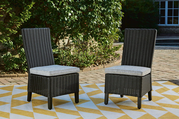Set of 2 black woven wicker side chairs with light gray cushions outdoors