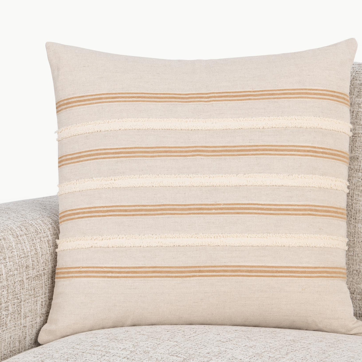 Natural 22 x 22 pillow with orange and cream striped band on upholstered seat