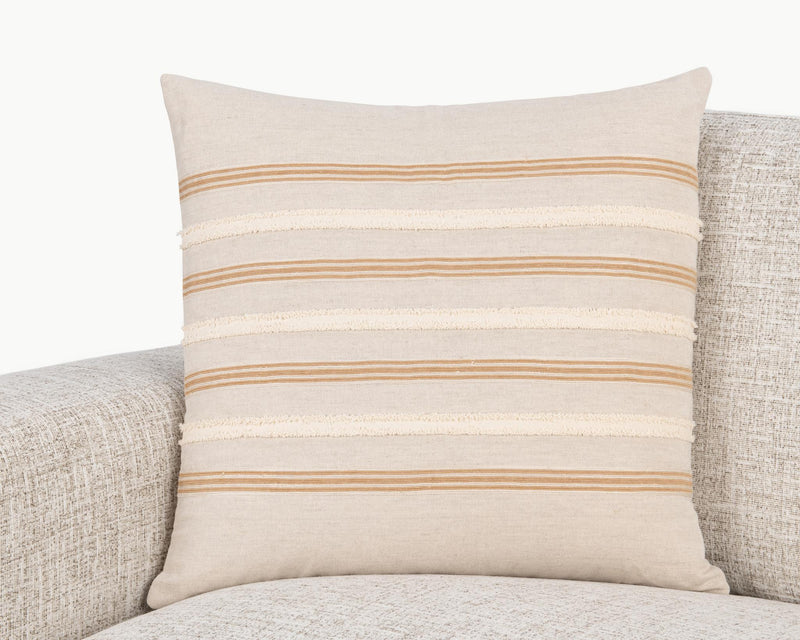 Natural 22 x 22 pillow with orange and cream striped band on upholstered seat